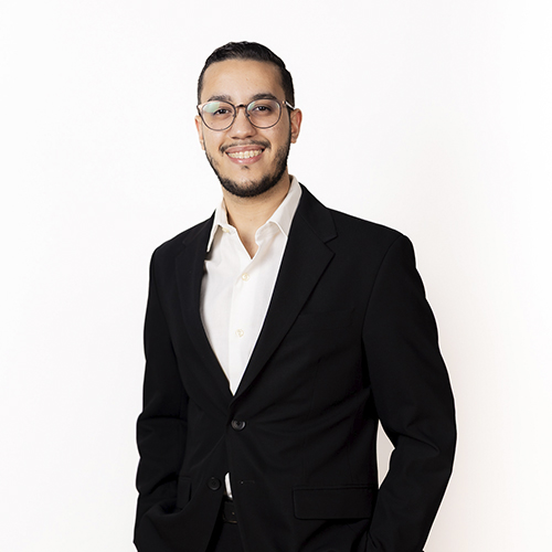Un profesional sonriente en traje oscuro posa para la foto del equipo de nuestra reconocida clínica dental.