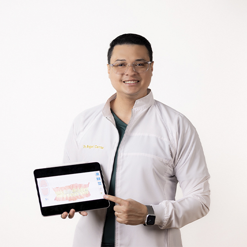 Un dentista joven y amigable sostiene una tableta que muestra un escaneo dental en 3D en nuestra clínica dental de vanguardia.