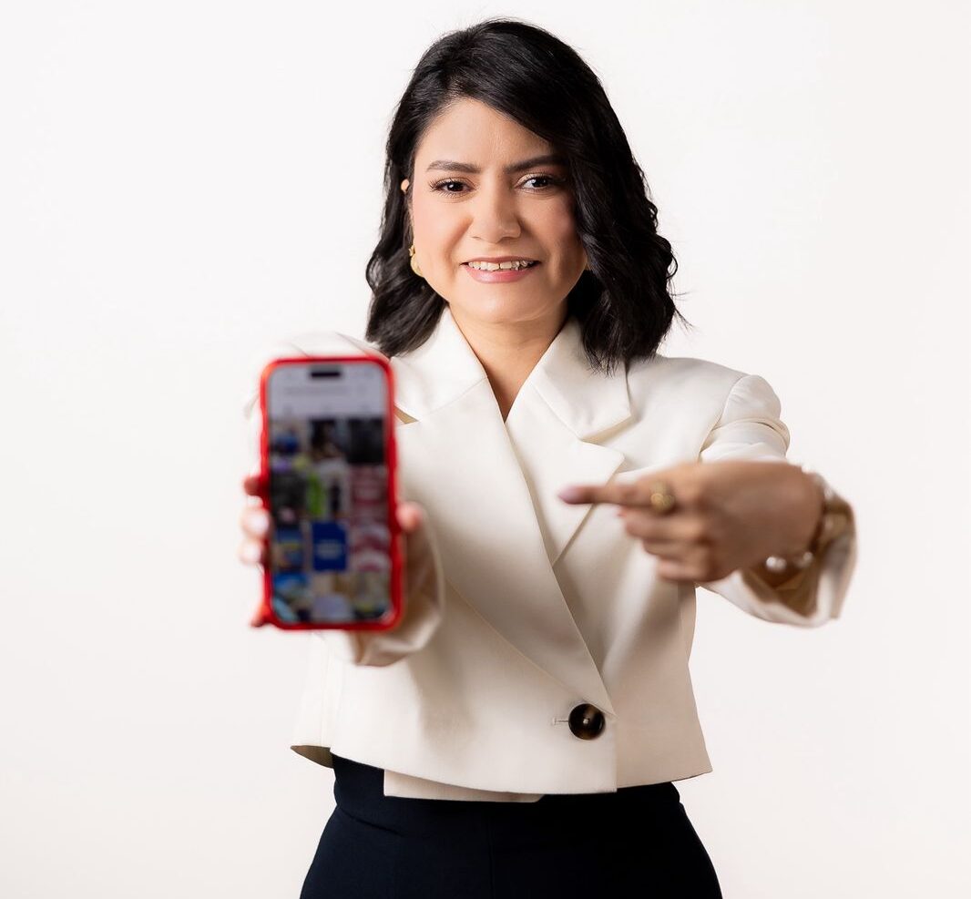 Una mujer muestra un teléfono celular con una imagen de dientes en una clínica dental.